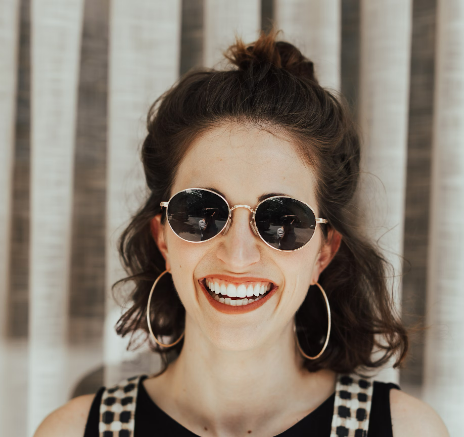 Smiling woman wearing sunglasses and striped dress
